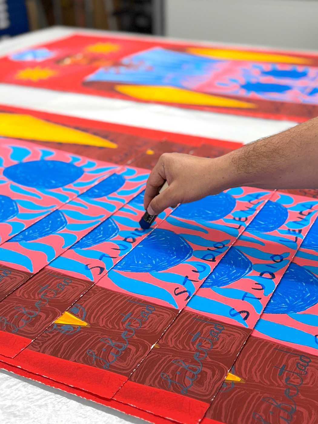 Studio Lenca hand-applying oil stick to each 'Libertad' print