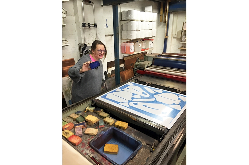 The artist working on the plate for the background colour
