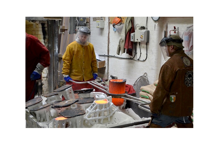 Molten bronze being poured into ceramic moulds 