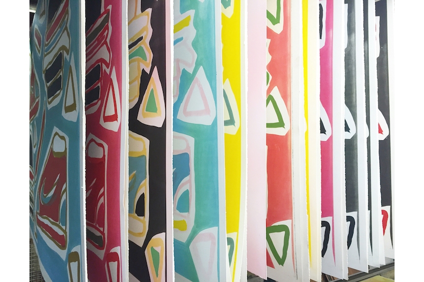 Completed prints hanging in the drying rack