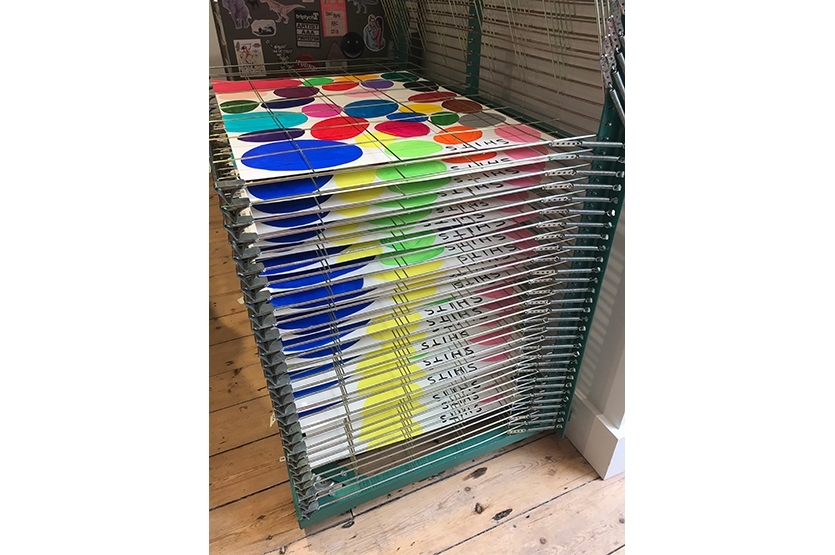 The wet acrylic paintings dry on a drying rack