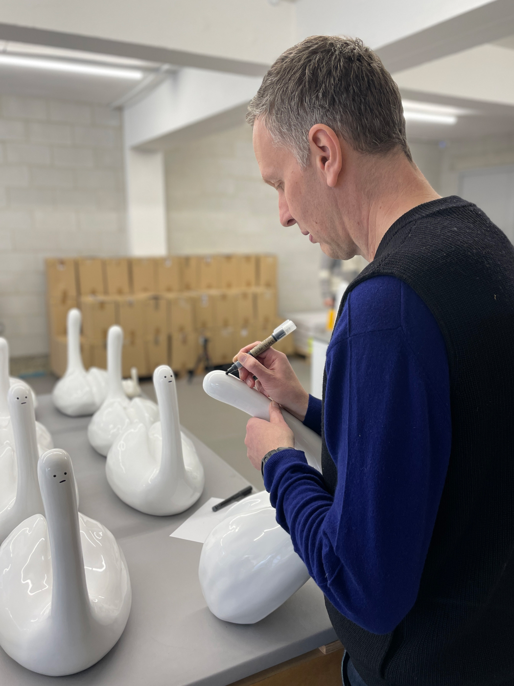 The artist hand-drawing the faces onto each sculptural multiple