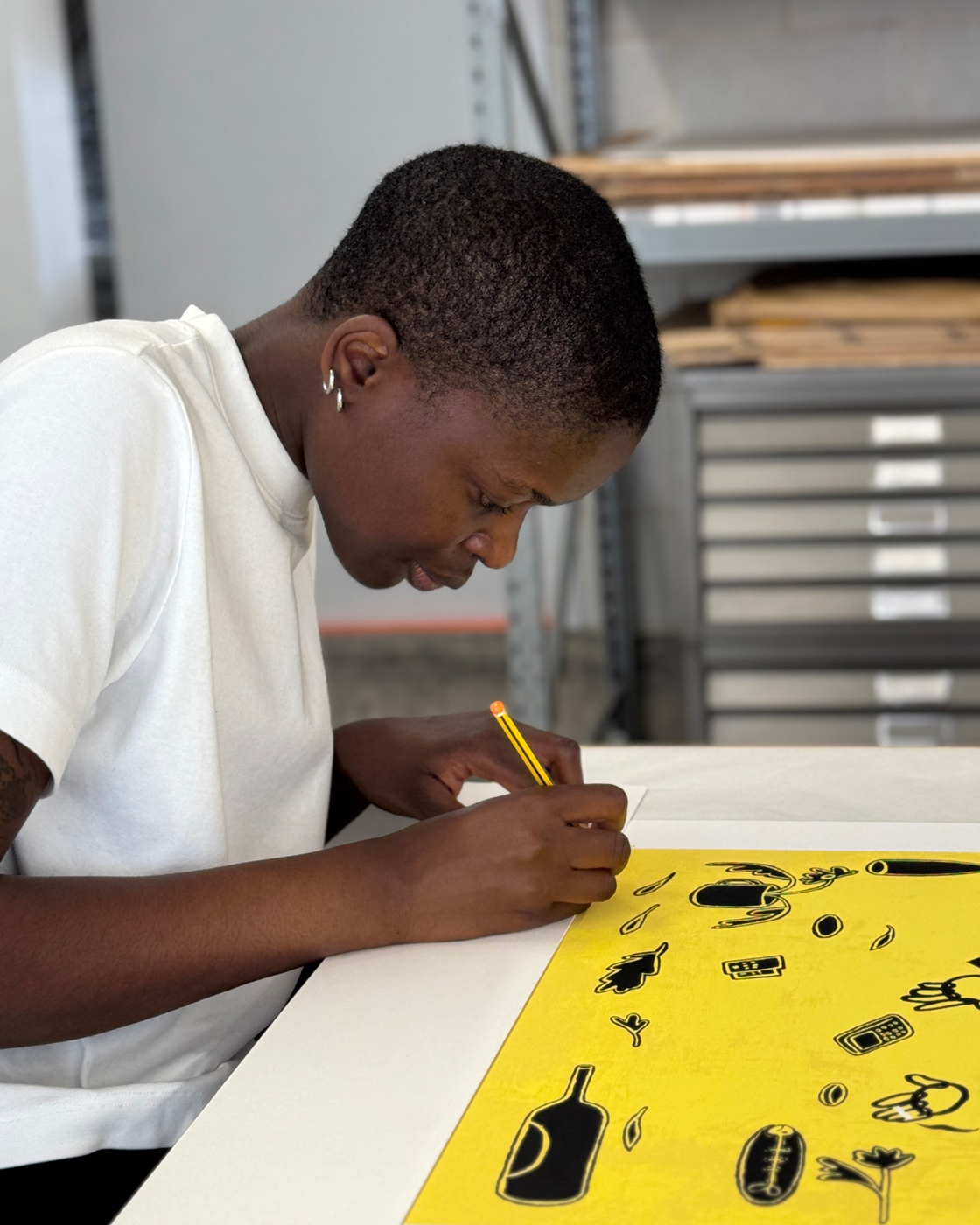 Joy Yamusangie signing their edition in Counter Studio, Margate