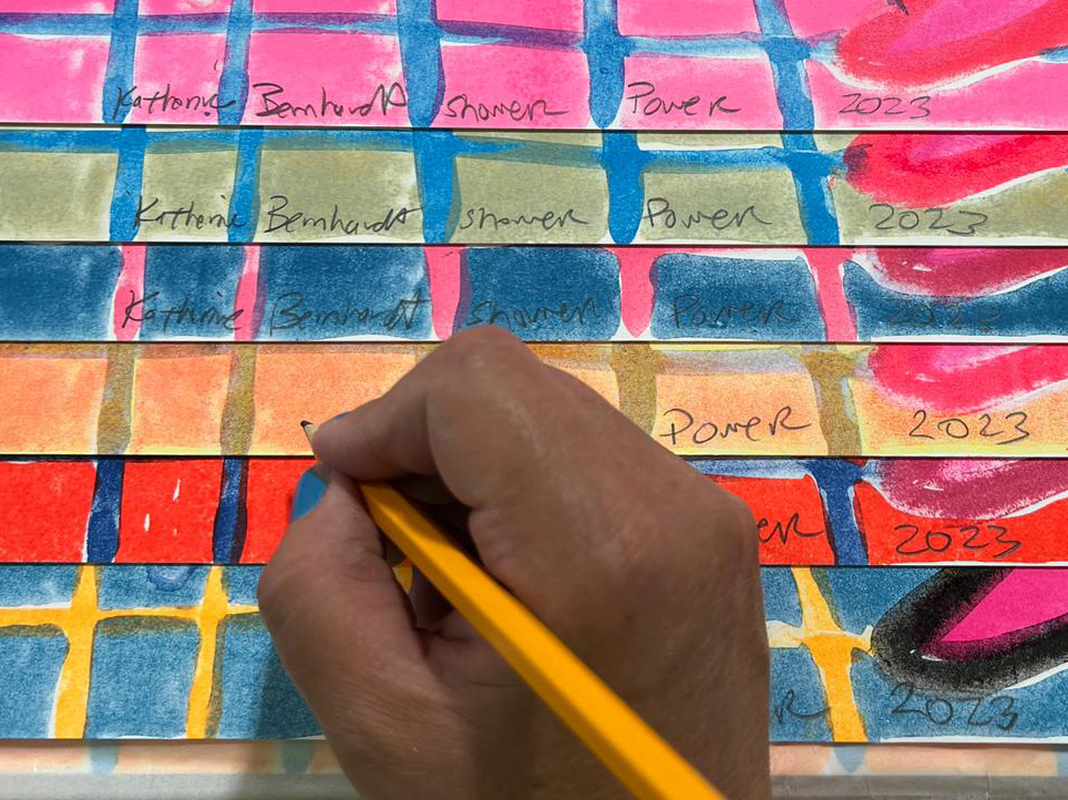 Katherine Bernhardt signing her print 'Shower Power' (2023)