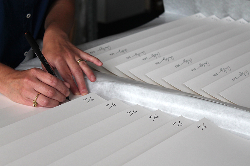 Anne Hardy signing, dating and numbering all the one hundred of the prints in the edition
