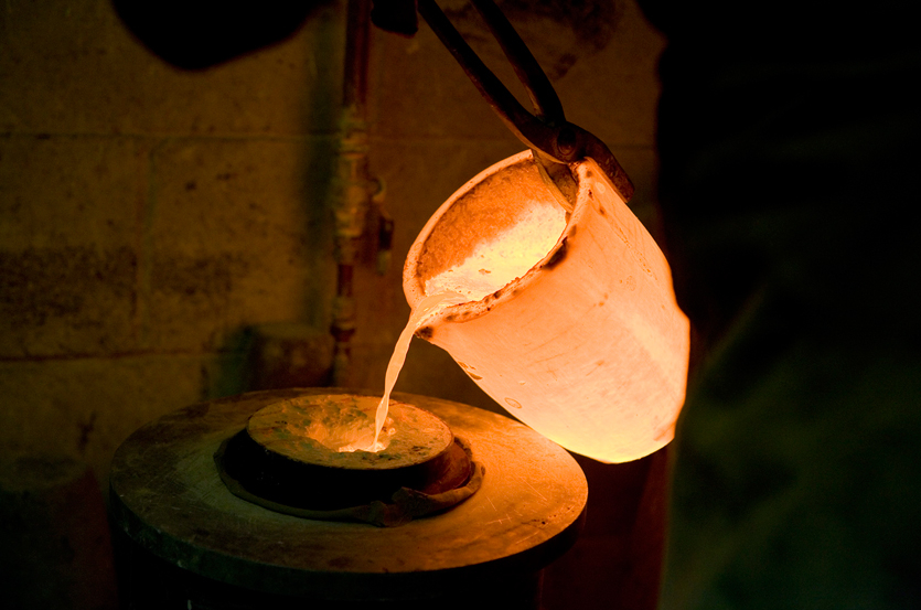 Molten bronze is poured into the cast