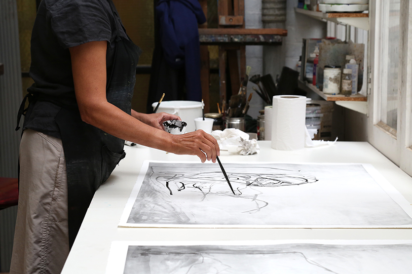 Emin paints with India ink onto a lithograph at Pauper's Press, London, 2017.