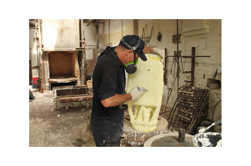 Removing the ceramic mould from around the bronze sculpture