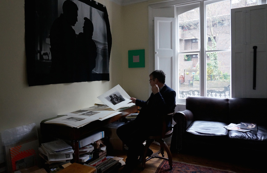 John at home choosing the edition from a selection of collages