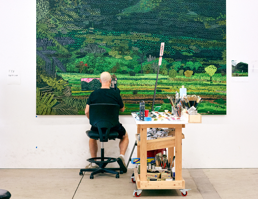 Jonas Wood in his studio painting Hanalei Bay, 2021, © Aubrey Mayer, courtesy David Kordansky Gallery