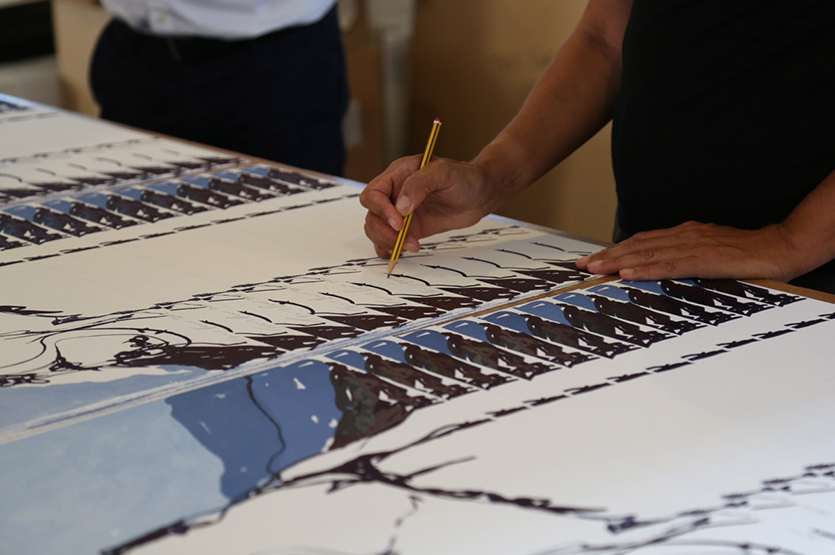 The prints are laid out in a reverse solitaire style for the signing